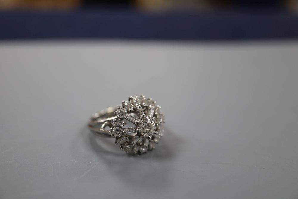 An 18ct and plat, diamond cluster ring, in a raised setting, size J, gross weight 6.7 grams,